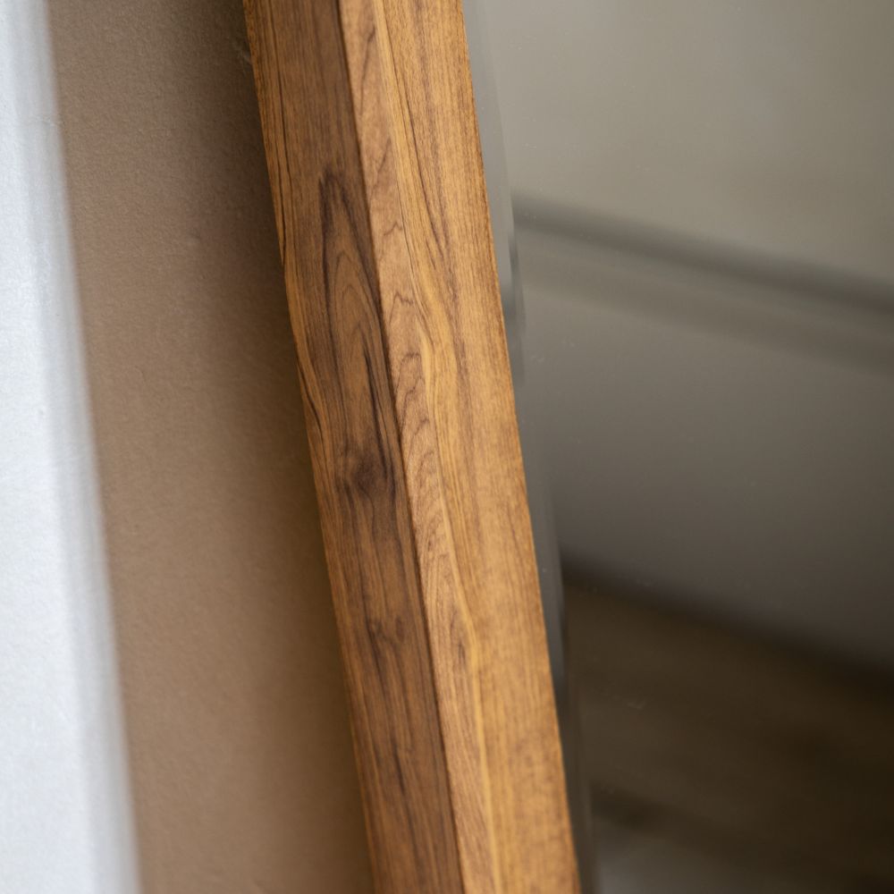 Angled close-up of a rectangular walnut wood mirror frame showing rich wood grain and smooth handcrafted edges.
