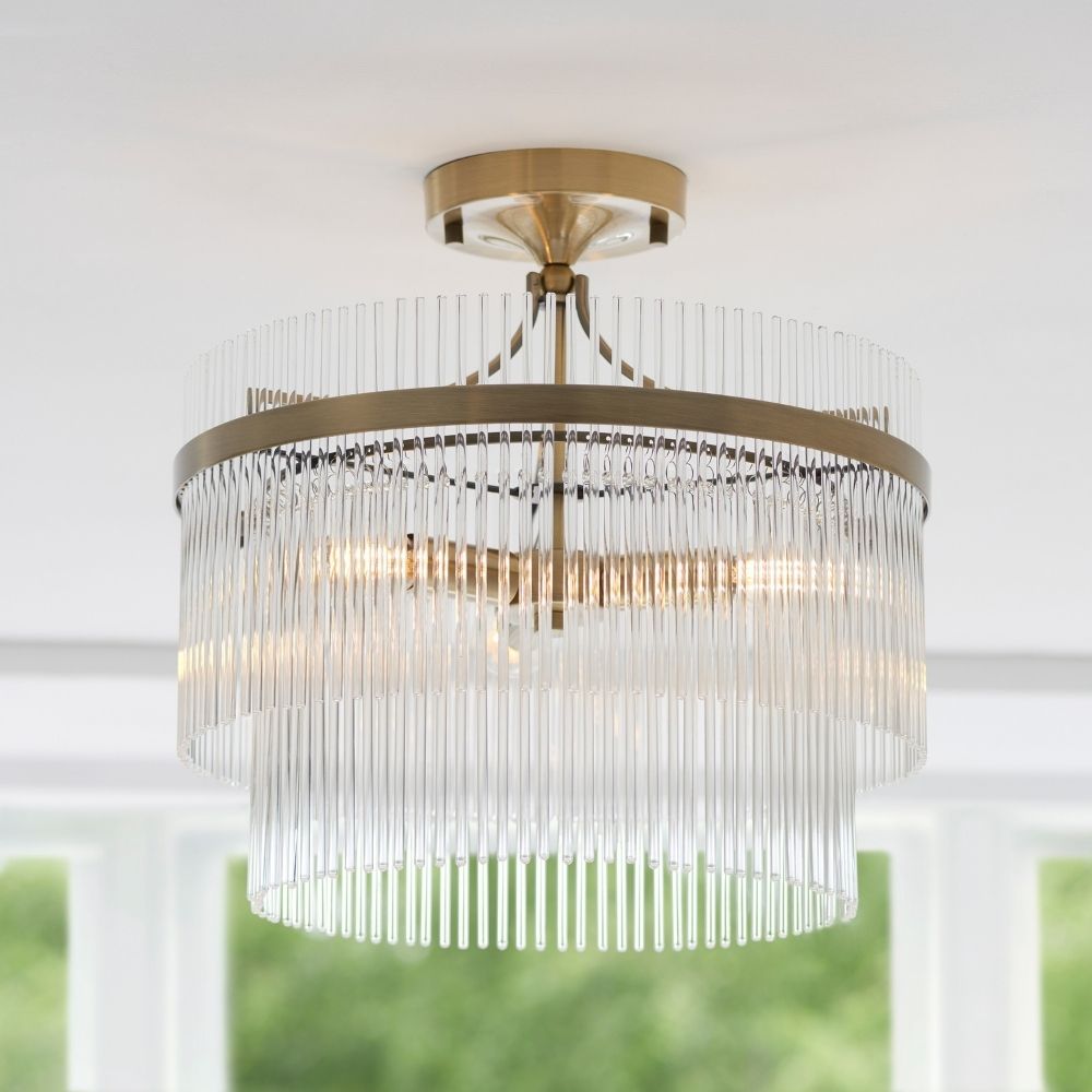 Antique brass decorative ceiling light with layered glass rods forming a tiered design and warm ambient lighting.
