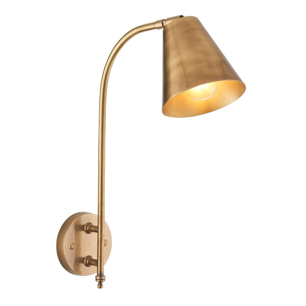 Antique brass wall mounted reading light with curved arm and conical metal shade isolated on plain background.