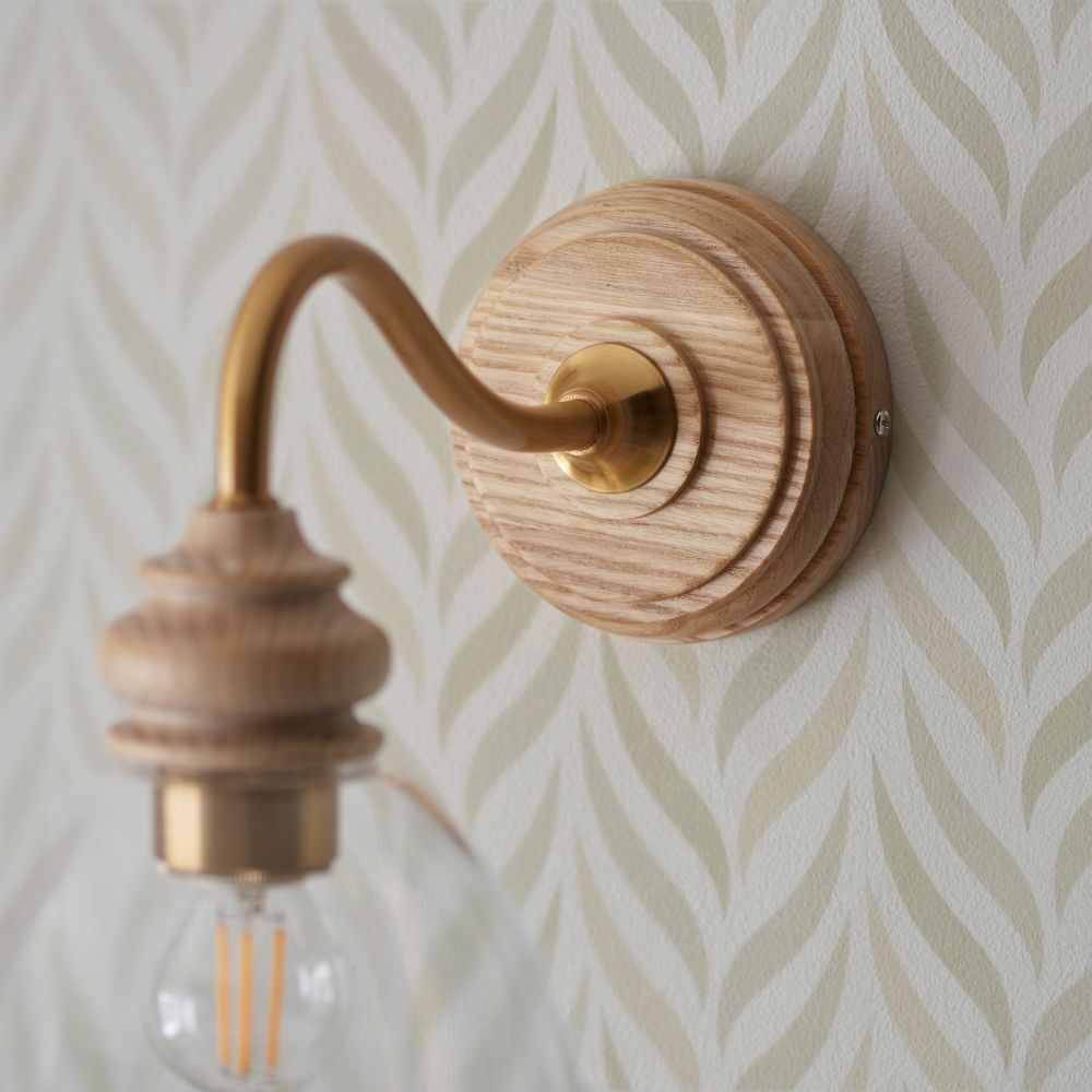 Close-up of ash wood lamp holder and exposed filament bulb within clear glass shade, highlighting warm ambient lighting.