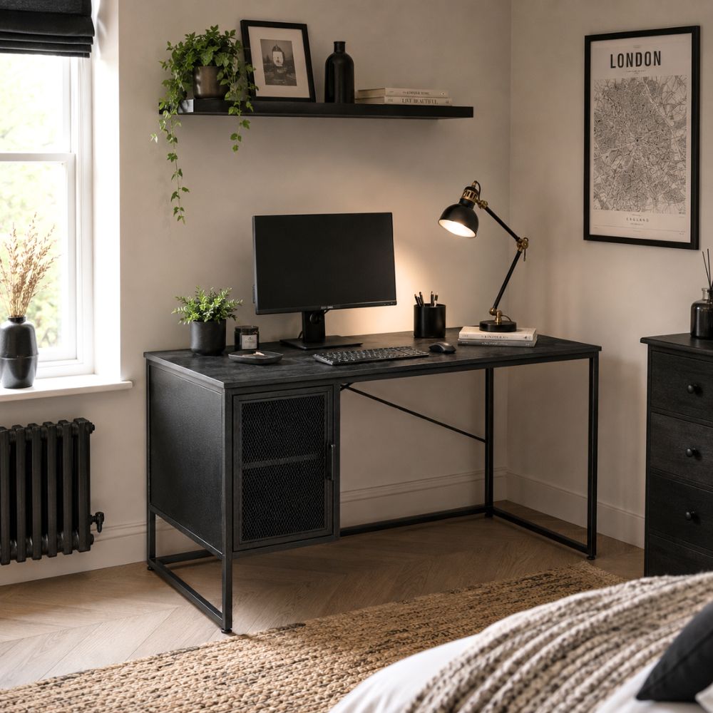 Black industrial-style home office desk with metal frame, integrated storage cabinet, computer monitor, desk lamp, and modern décor in a contemporary workspace.
