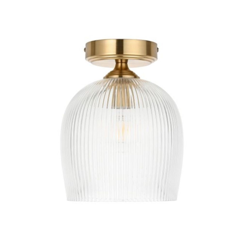 Front view of brass flush ceiling light with vertically ribbed glass shade on a neutral background.
