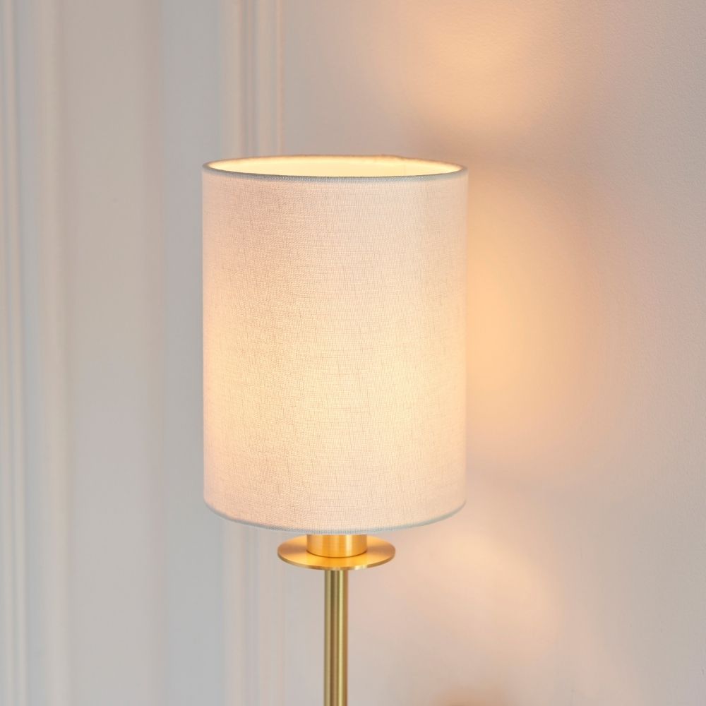 Detailed view of brass wall light mounting plate and arm with brushed finish fixed to a wall.
