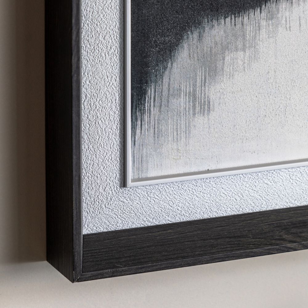 Close-up detail of dark wood-effect picture frame with textured mount surrounding a neutral landscape artwork.