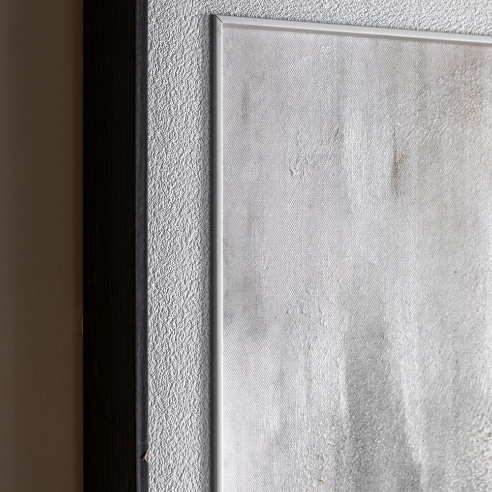 Detailed close-up of framed abstract canvas artwork highlighting textured surface, soft neutral background and dark wood-effect frame.