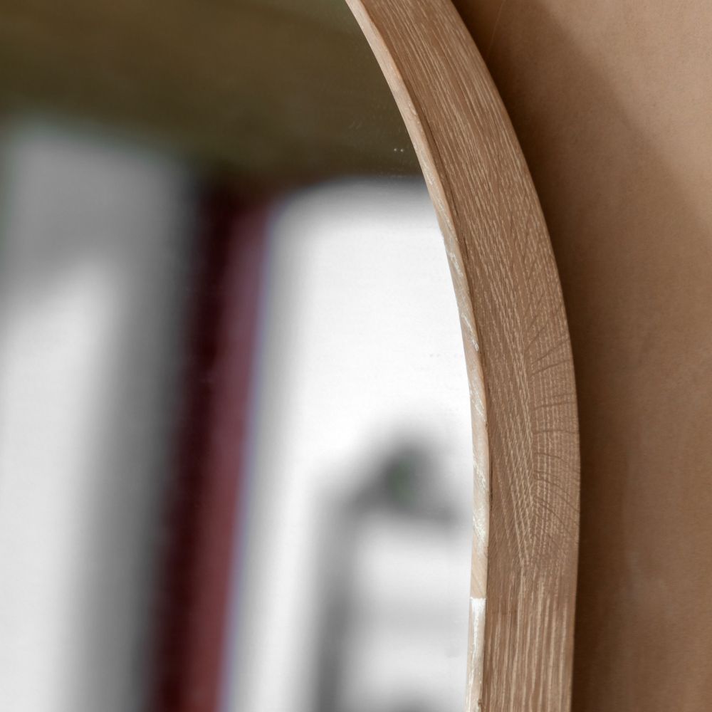 Close-up detail of a light oak arched mirror frame showing natural wood grain and smooth curved edges.