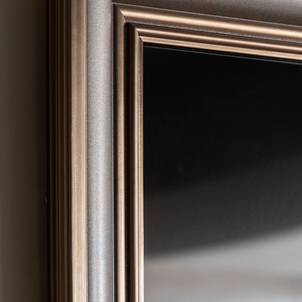 Close-up detail of a metallic champagne-toned frame surrounding monochrome seascape wall art.