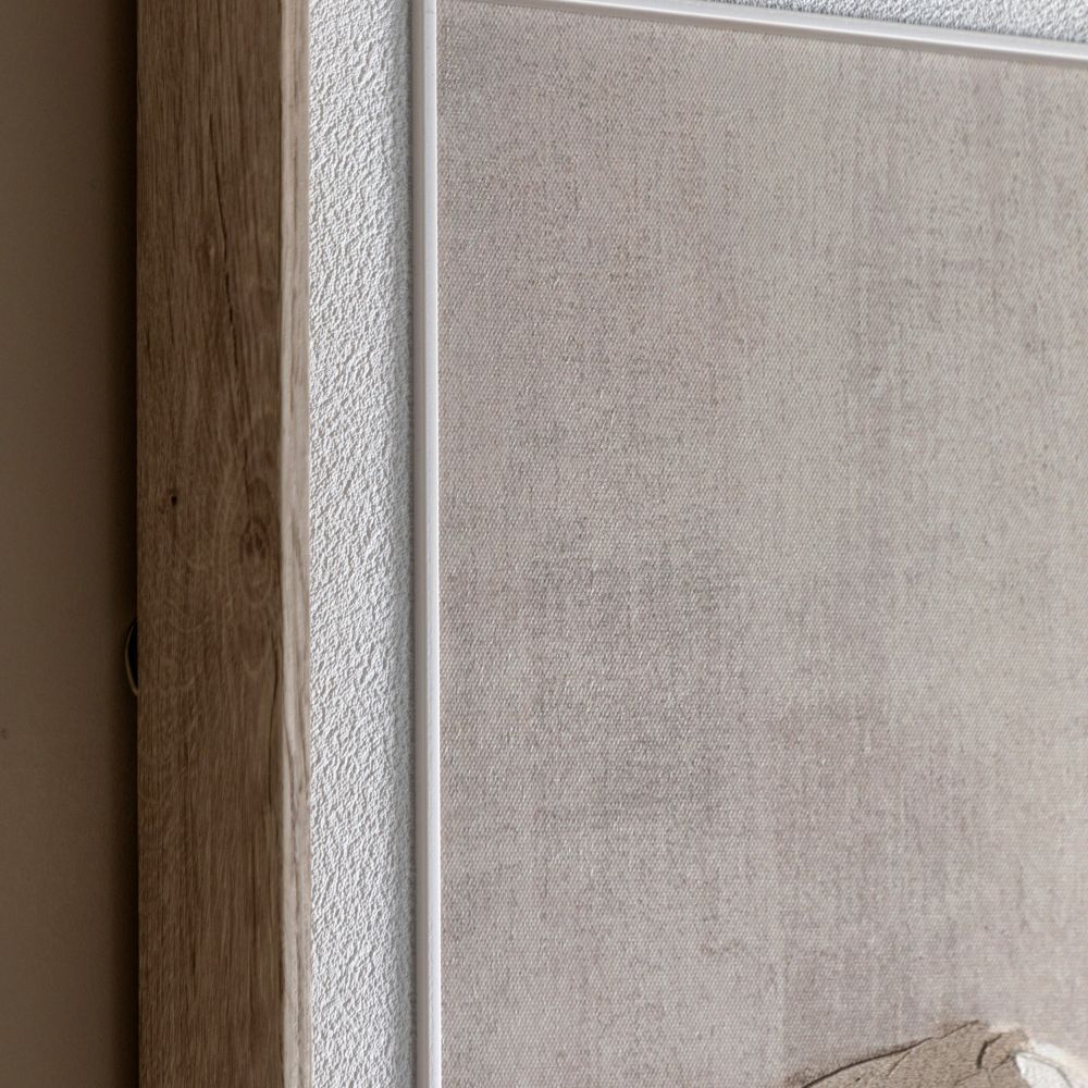 Close-up detail of a natural wood frame and textured canvas on abstract mountain landscape wall art.