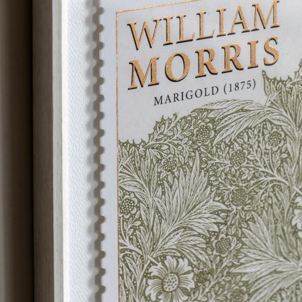 Close-up detail of William Morris Marigold print with intricate floral illustration, gold foil typography and textured frame.