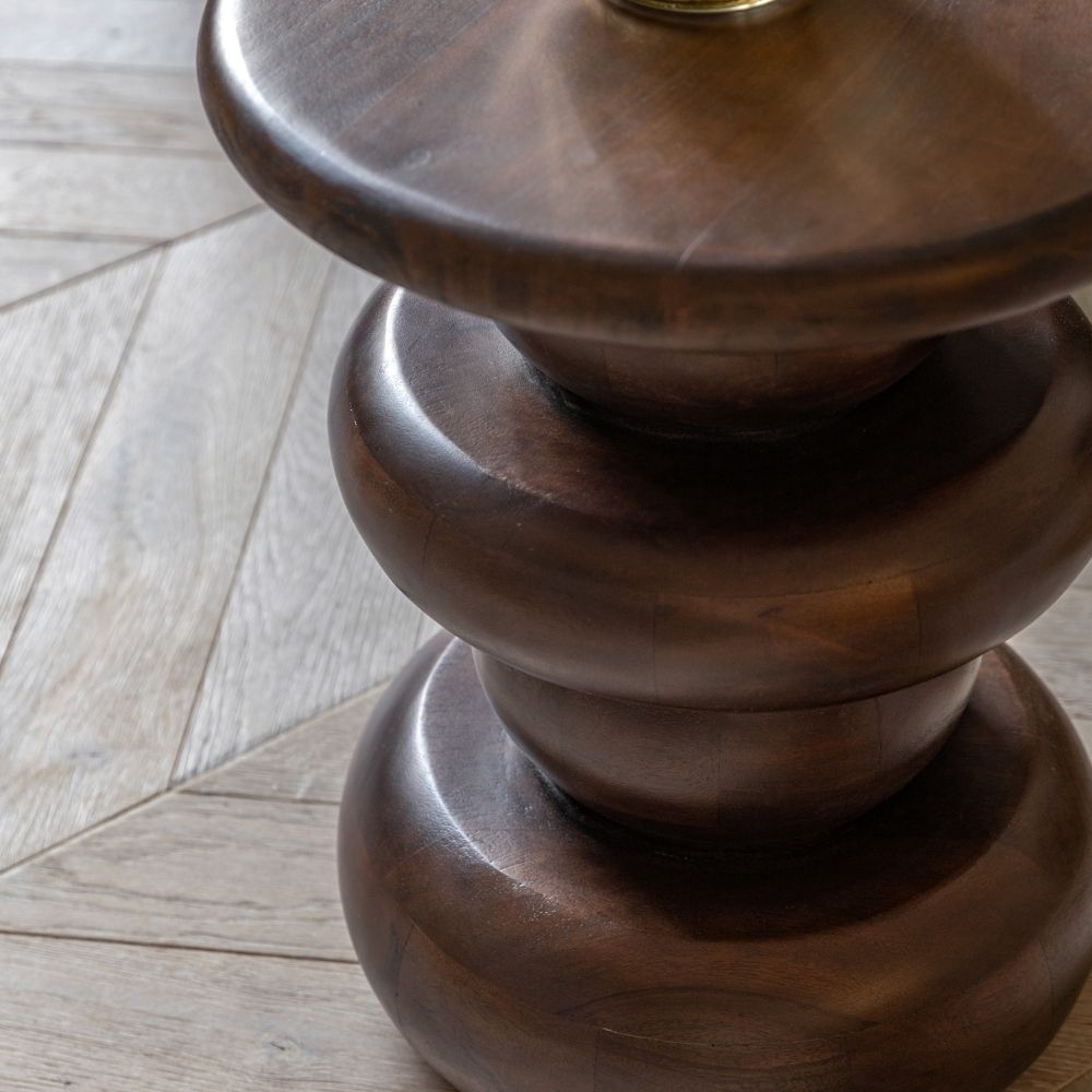 Close up of dark mango wood side table showing layered rounded base design and rich wood grain texture.