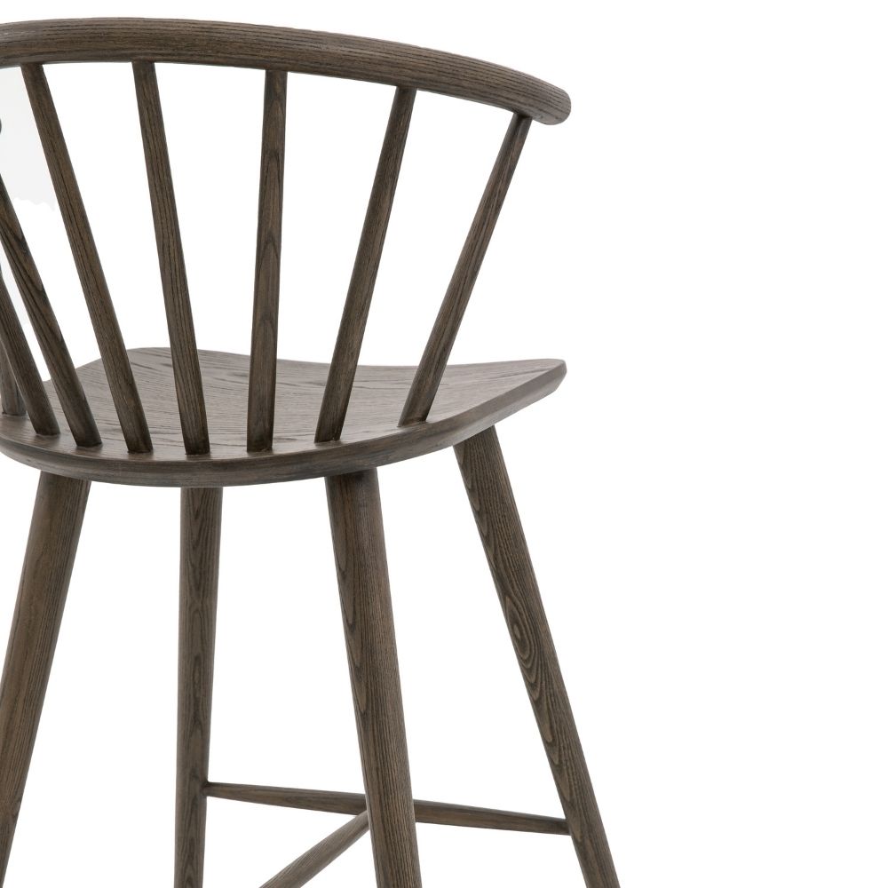 Close-up of dark oak spindle backrest showing curved top rail and vertical spindles with visible wood grain.
