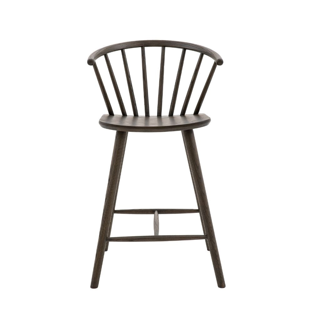 Dark oak wooden bar stool with spindle backrest, curved seat and angled legs shown against a plain light background.