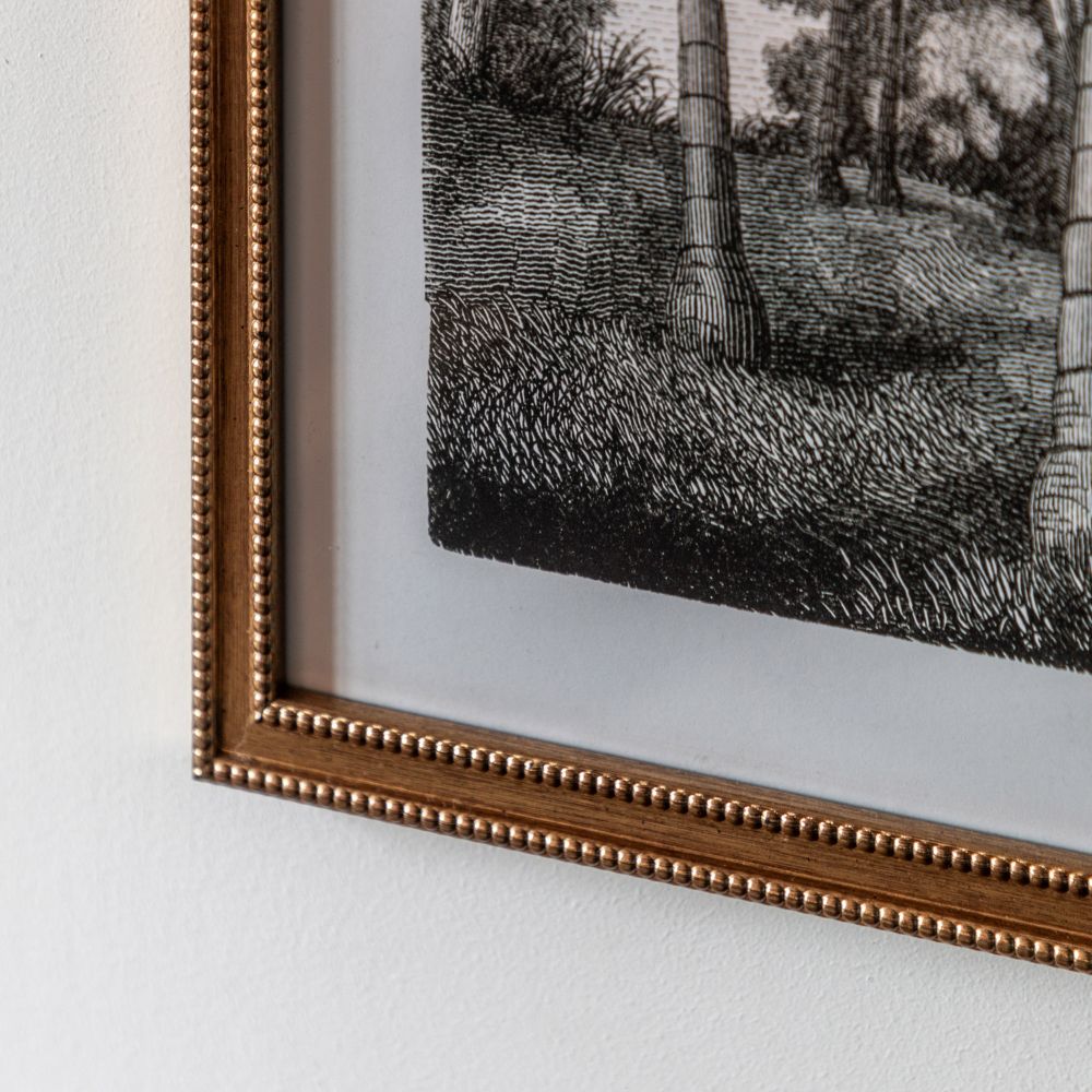 Detailed close-up of a monochrome botanical palm print with fine illustration detail and decorative gold beaded frame.