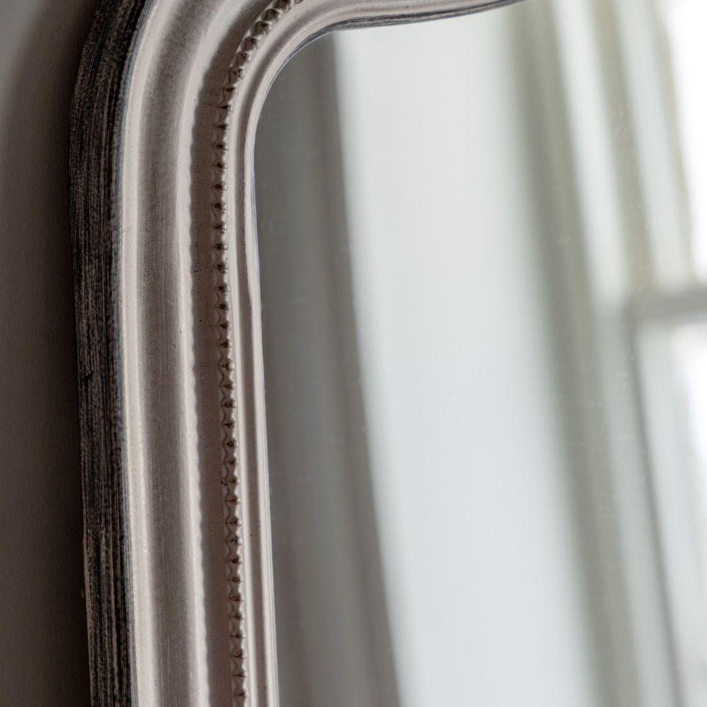 Detailed corner close-up of a distressed grey arched mirror frame with elegant curved shaping and subtle antique finish.