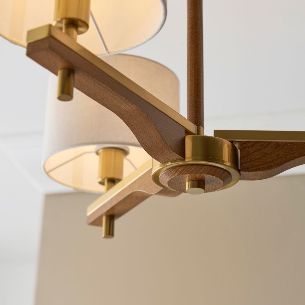 Detailed view of ash wood curved arm and brass fittings on a contemporary semi flush ceiling light.