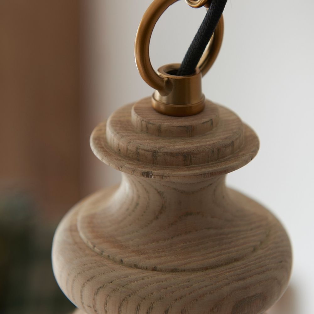 Detailed view of ash wood ceiling light fitting with brass chain connection and black cable showcasing craftsmanship.