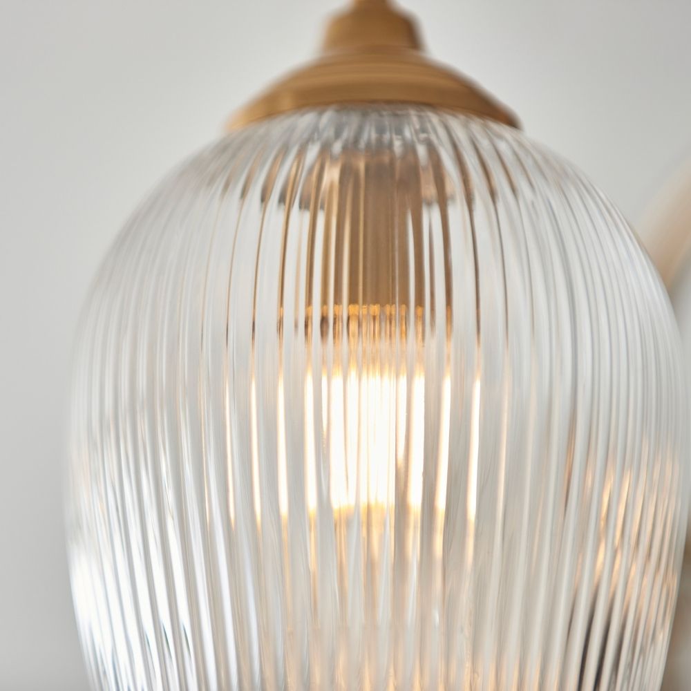 Detailed close up of ribbed glass shade showing texture and warm light diffusion from the bulb.