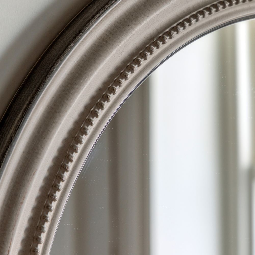 Detailed close-up of a round grey mirror frame with elegant beaded trim and softly distressed vintage finish.