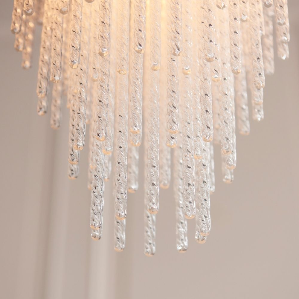 Detailed view of layered glass drops on a brass pendant light creating a cascading decorative lighting effect.