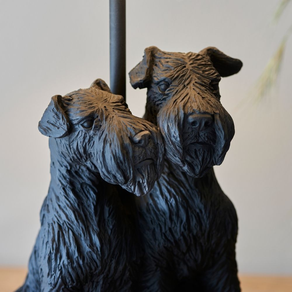 Close-up of double dog resin lamp base highlighting intricate fur texture and sculpted design beneath a soft fabric lampshade.