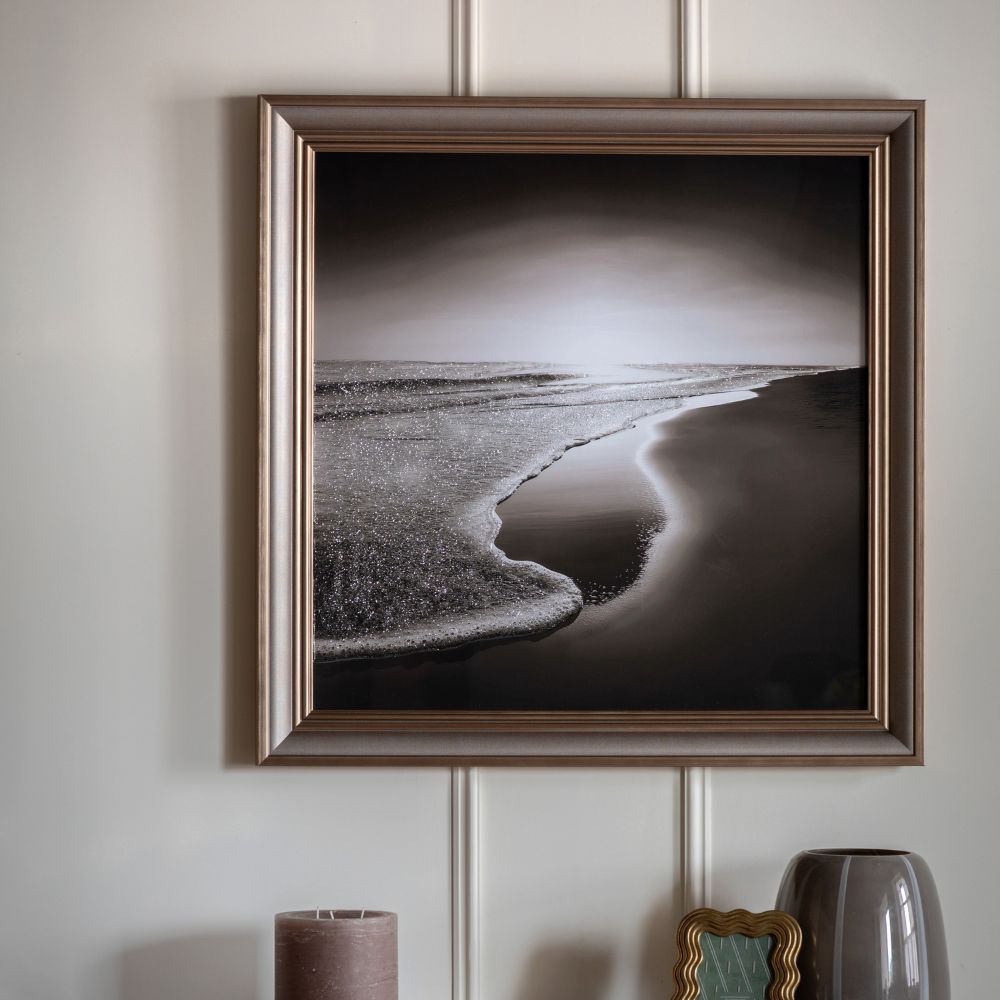Framed monochrome seascape wall art print featuring gentle waves on a shoreline in soft black and silver tones.