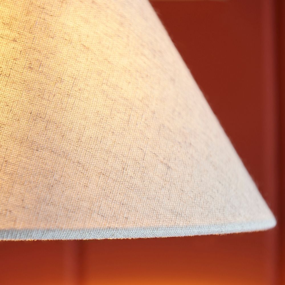 Detailed close up of linen lampshade fabric texture illuminated with soft warm light.