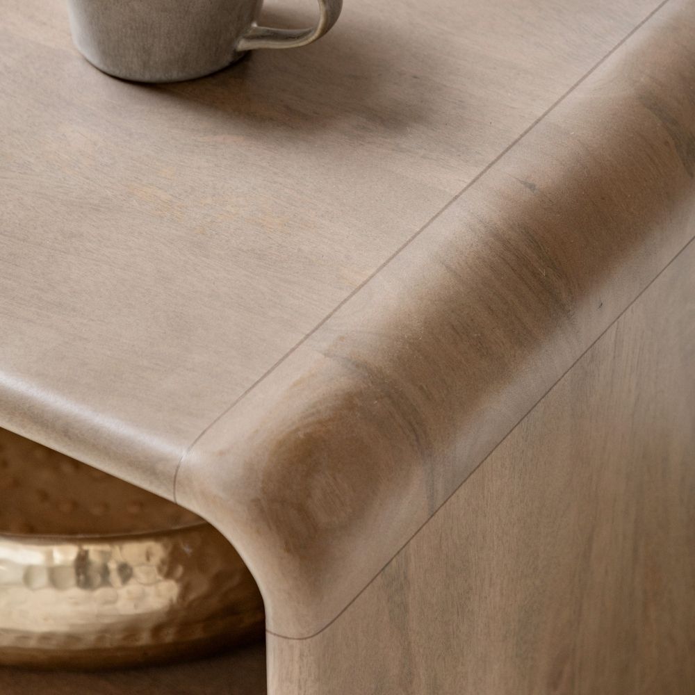 Detailed view of rounded corner edge showing natural mango wood grain and smooth finish on the coffee table surface.