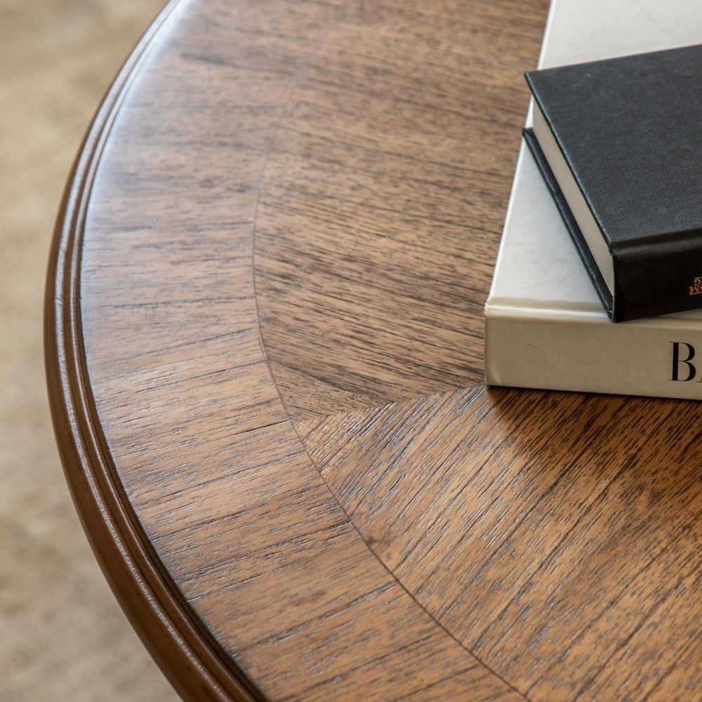 Detailed view of marquetry tabletop showing natural wood grain pattern and smooth rounded edge in warm oak tone.