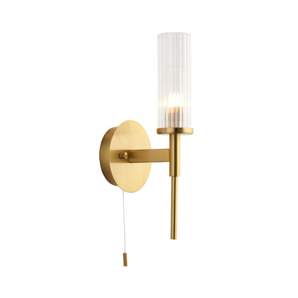 Minimalist brass wall sconce featuring a ribbed glass shade, slim metal stem and practical pull cord switch.