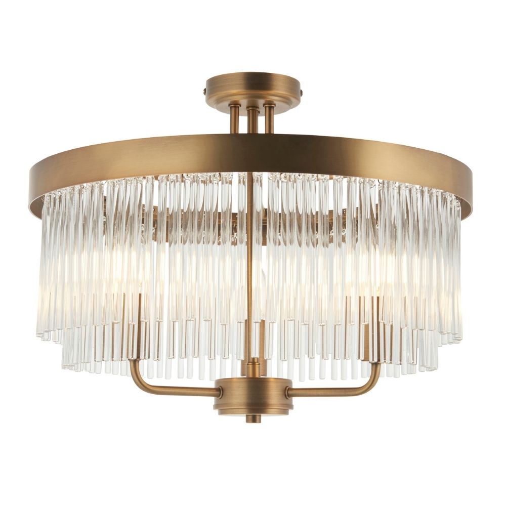 Contemporary brass ceiling light with clear glass rod detailing in a semi flush mount design on a plain background.