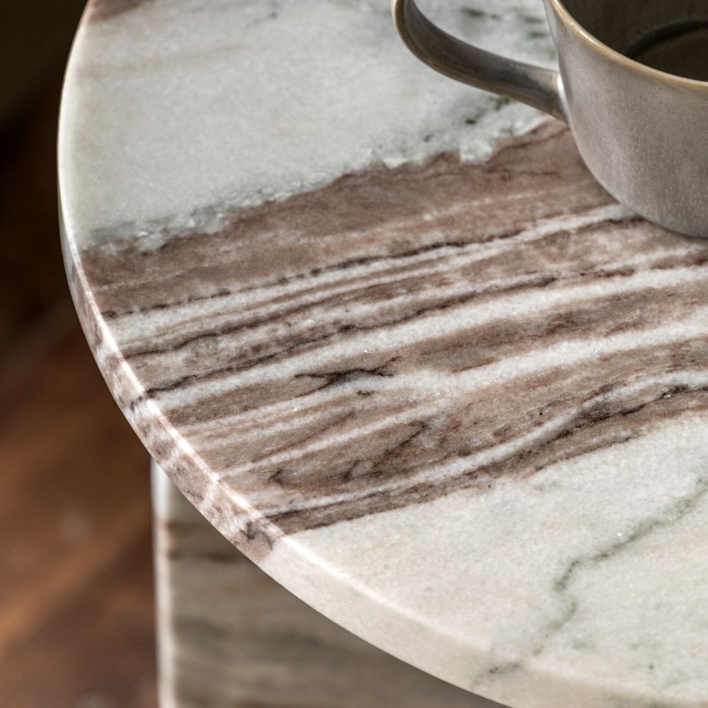 Close up of natural marble side table highlighting detailed beige and grey veining with smooth polished surface.