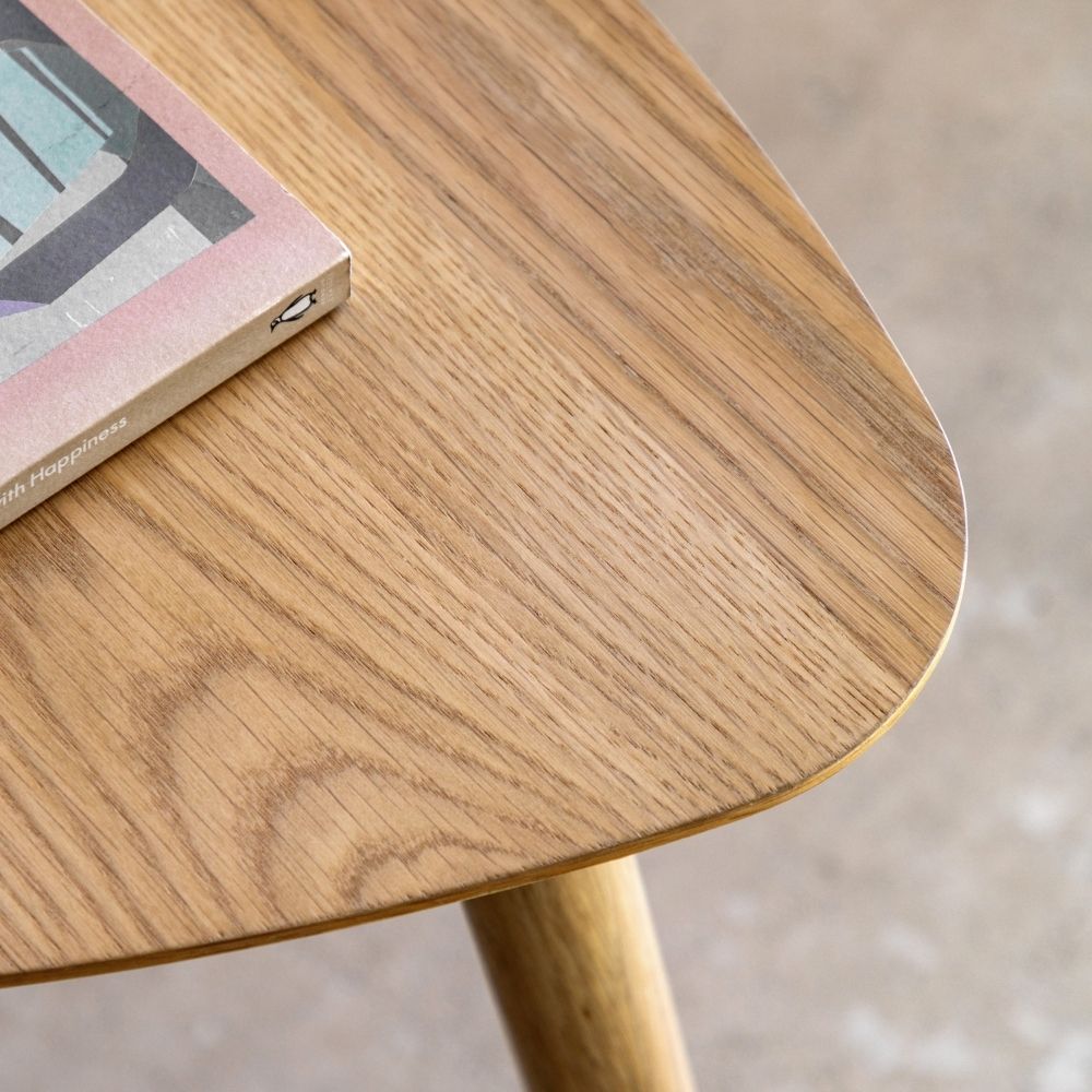 Close up of natural oak tabletop showing fine wood grain texture and smooth rounded triangular edges.
