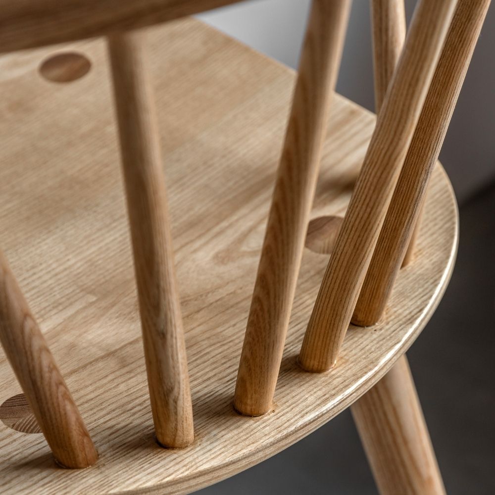Close-up of natural oak spindle backrest showing smooth rounded spindles and curved top rail with visible wood grain.
