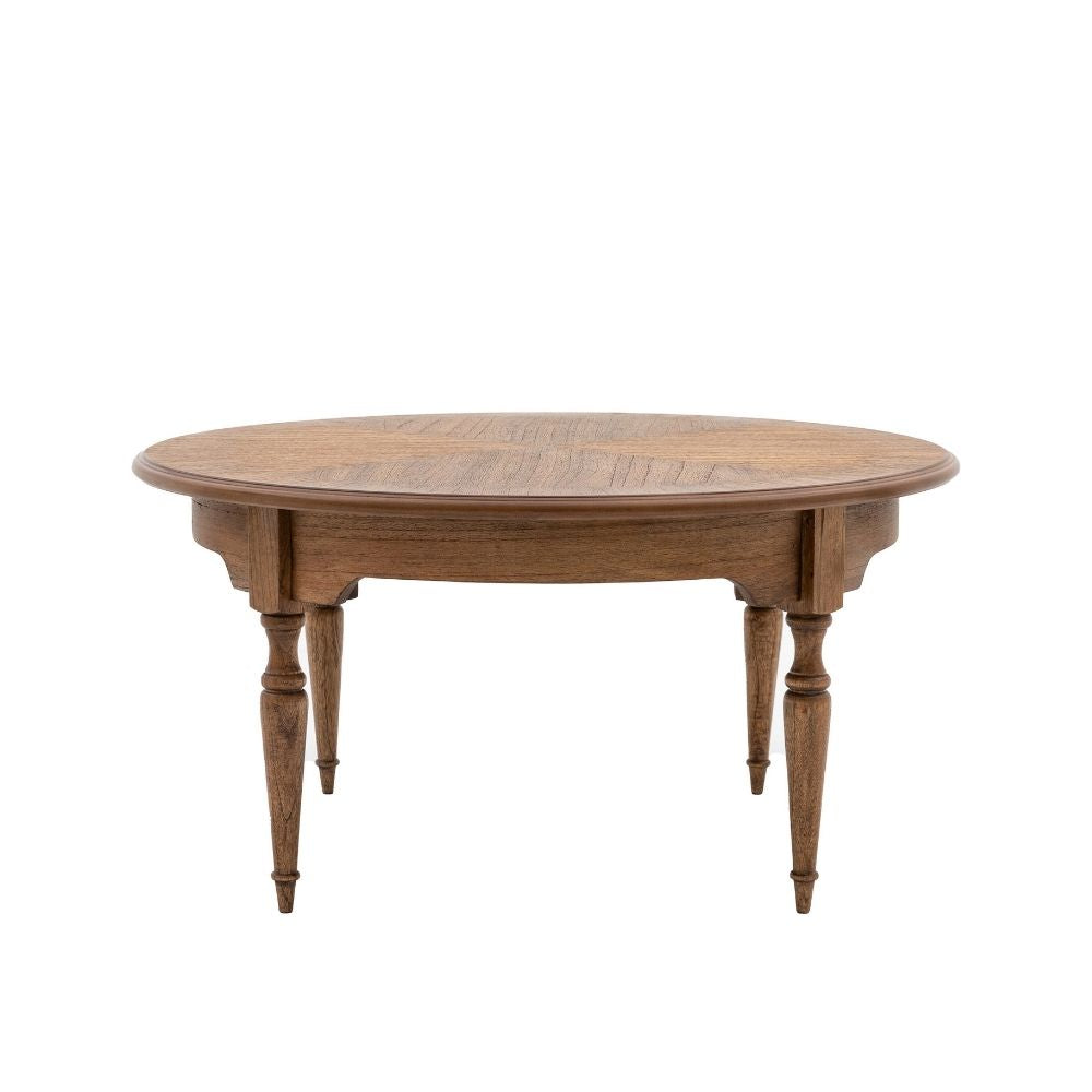 Round coffee table in natural mindy wood featuring classic turned legs and elegant apron detail on a plain background.
