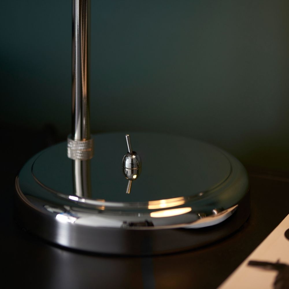 Detailed view of polished nickel lamp base with integrated switch highlighting reflective finish and minimalist design.