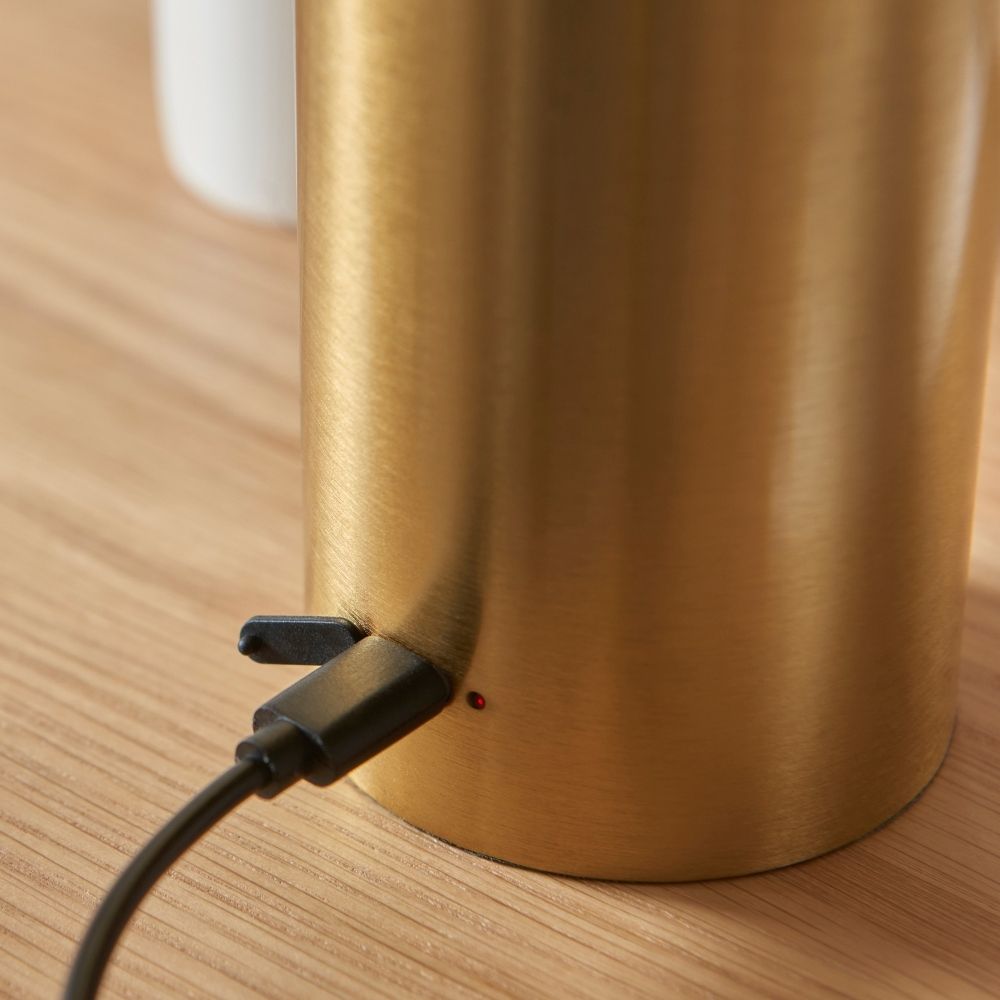 Detail of brass table lamp base with USB charging port, highlighting rechargeable functionality and premium metal construction.
