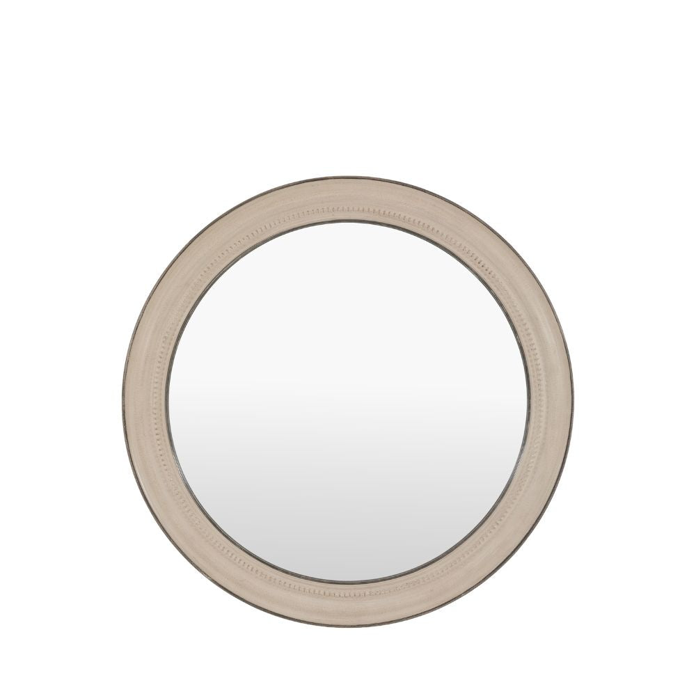 Round distressed grey wall mirror displayed above a wooden console table with decorative vases and a small potted plant.