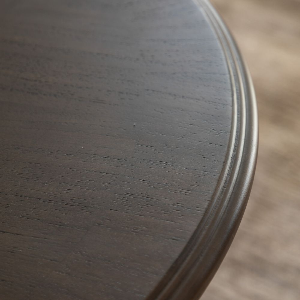 Close up of rounded edge detailing showing smooth finish and subtle marquetry grain on dark wood coffee table.