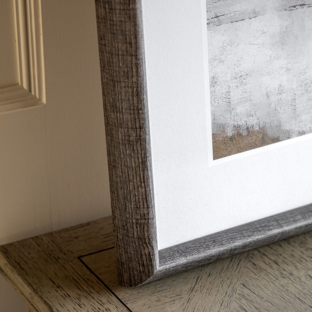 Detailed view of rustic wood-effect frame surrounding a neutral abstract art print with soft layered textures.
