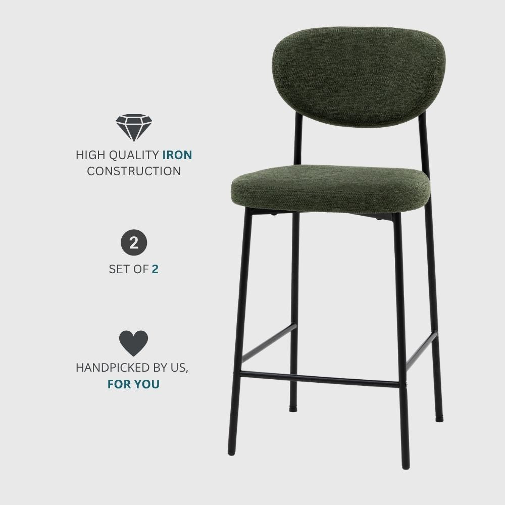Promotional image of a set of two green fabric upholstered bar stools with black metal legs and iron construction on a light background.