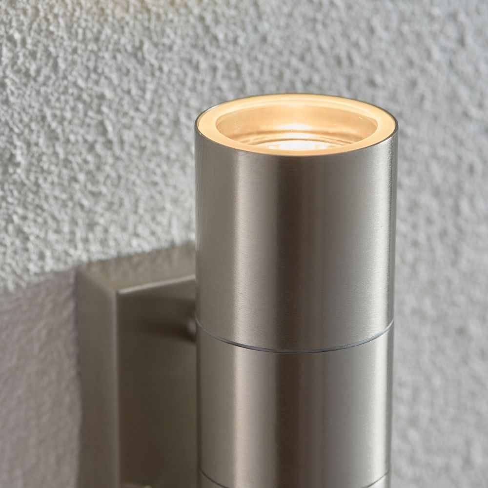 Close up of stainless steel outdoor wall light showing integrated PIR sensor and brushed metal finish detail.