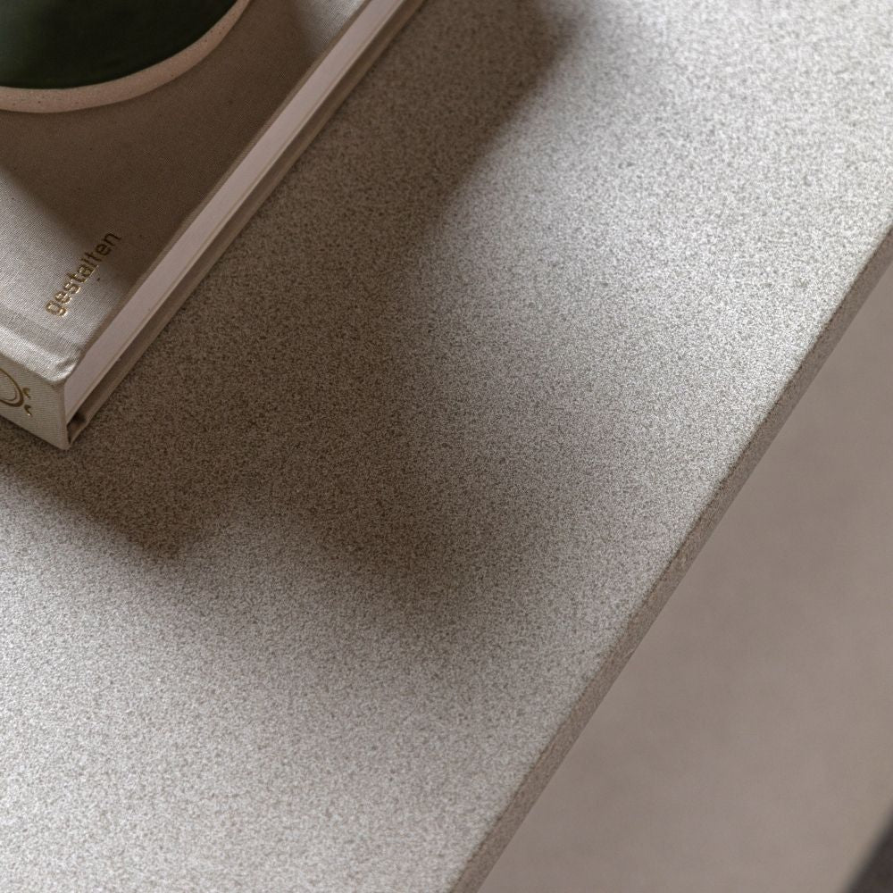 Detailed view of textured concrete surface showing fine grain finish and neutral tone on sculptural coffee table.