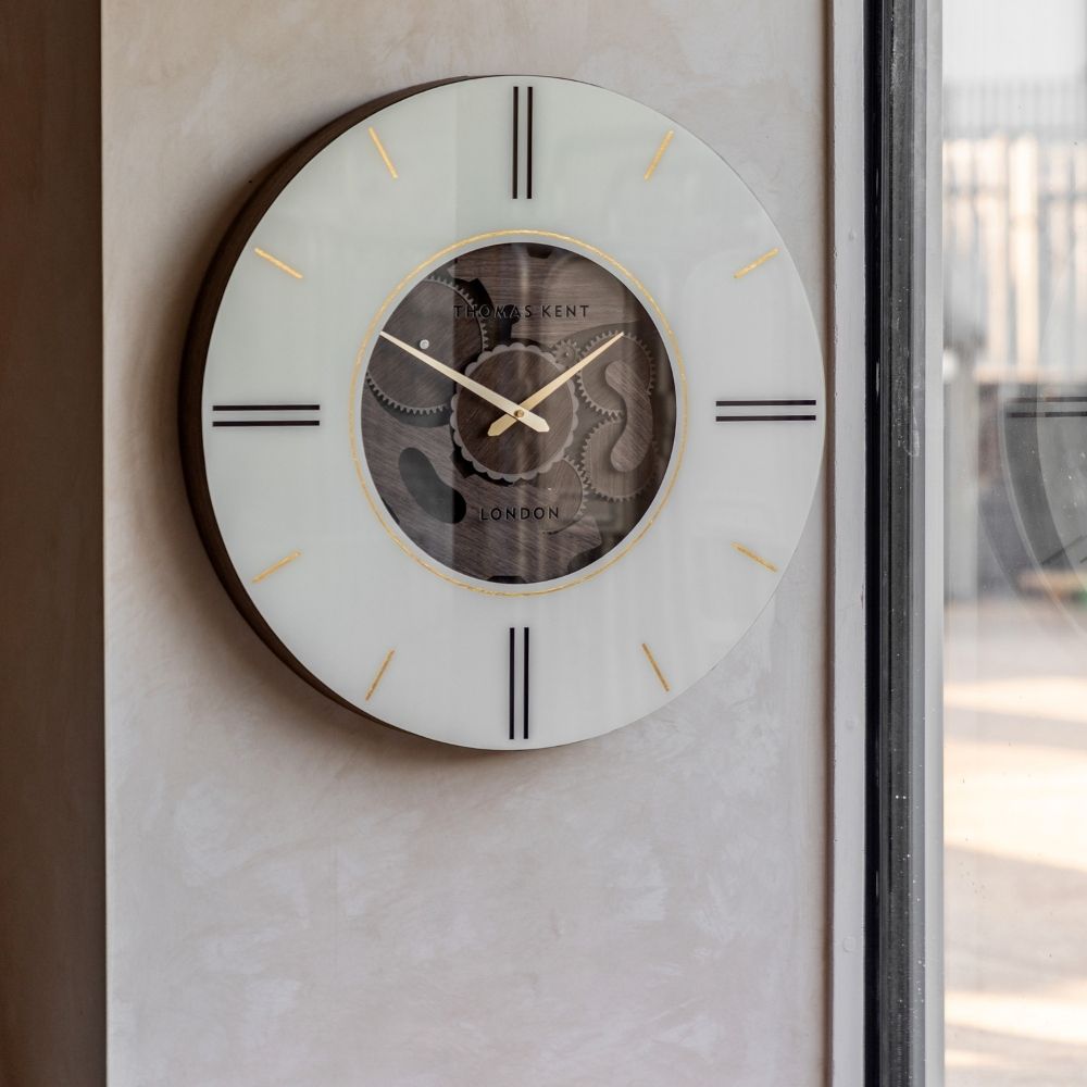 Thomas Kent Cogger dark walnut 60cm cog wall clock with cream dial, exposed wooden gears and gold detailing styled by a window
