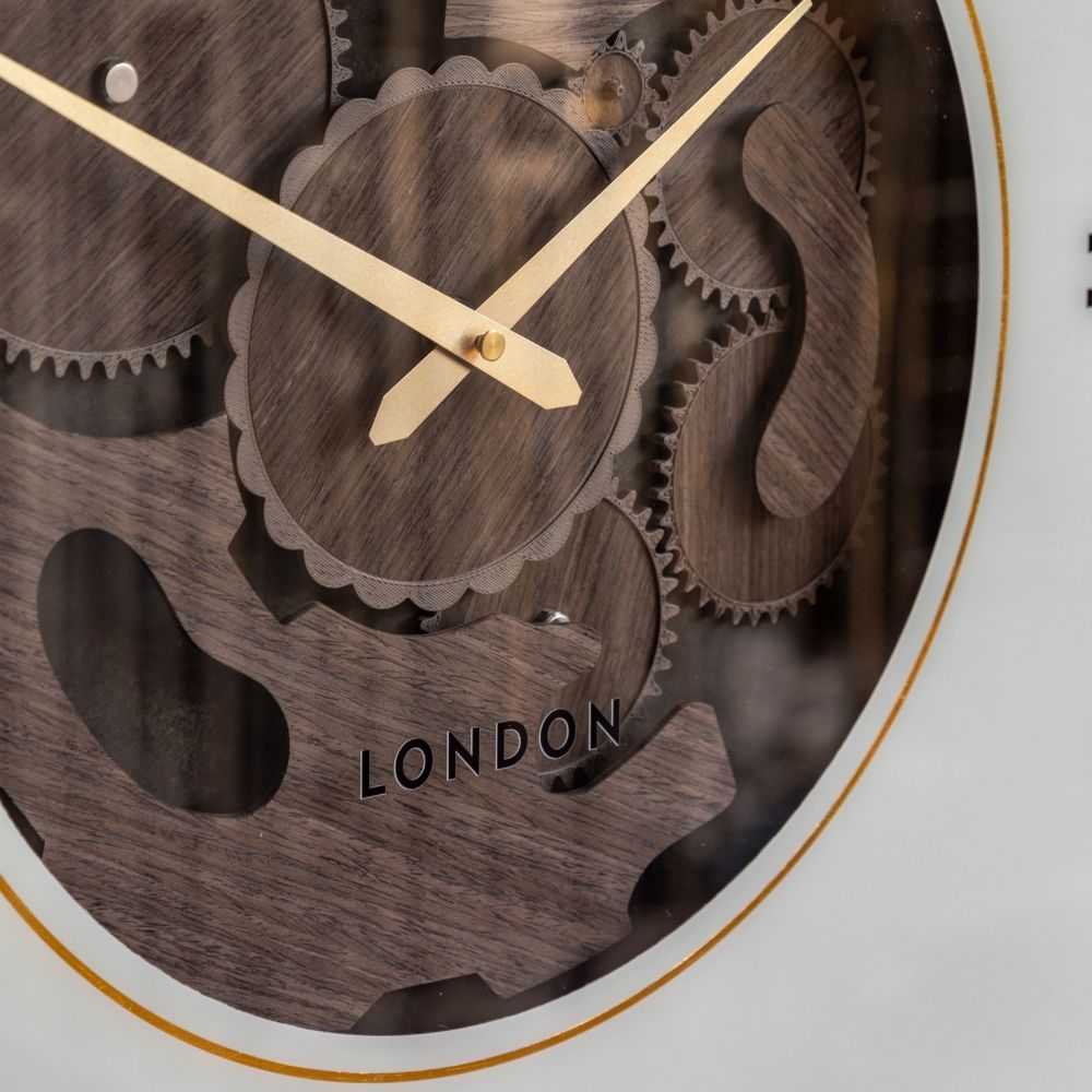 Close-up of the Thomas Kent Cogger dark walnut wall clock showing its exposed wooden cog design, gold hands and decorative gear detail