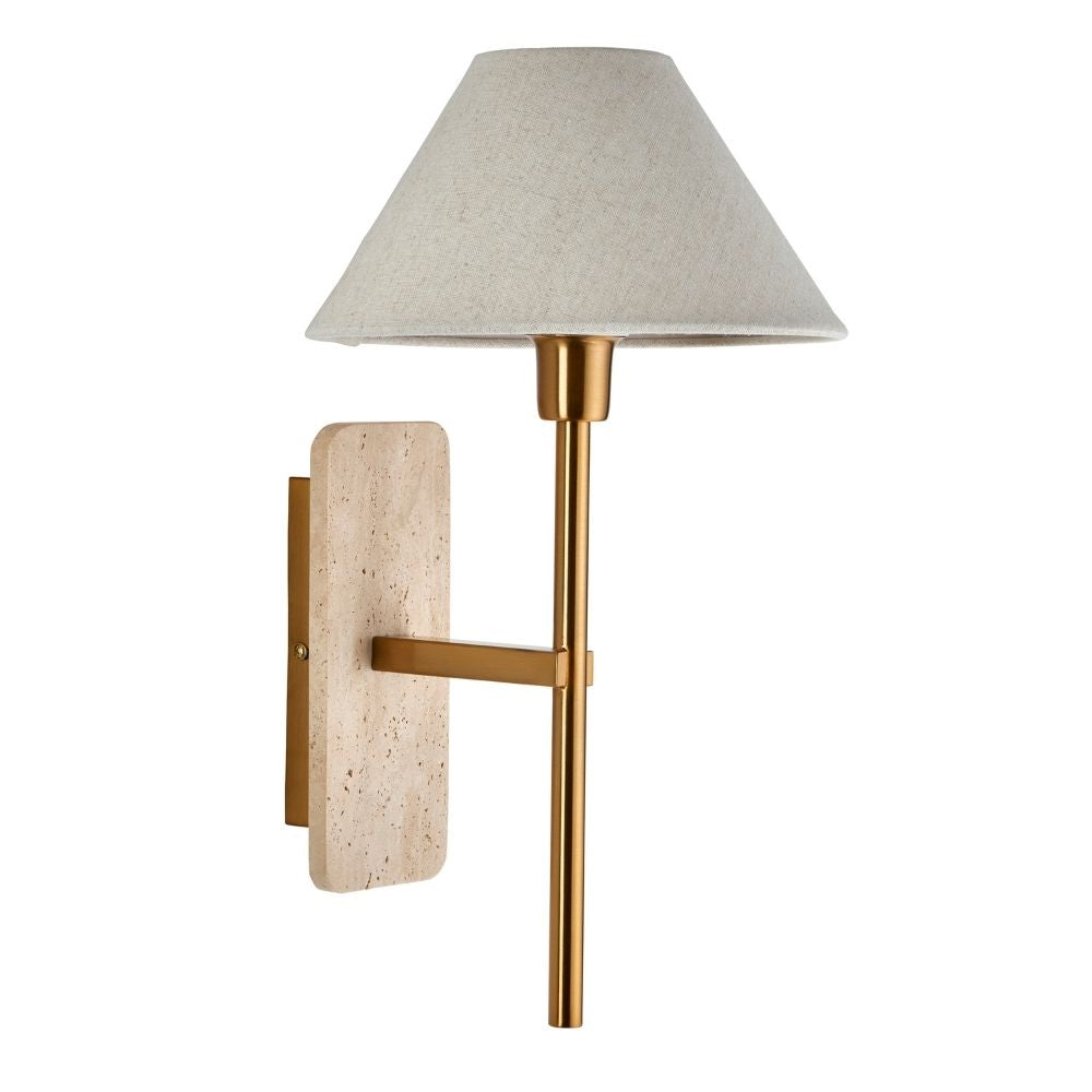 Modern wall sconce with textured travertine stone backplate, slim brass stem and tapered linen lampshade on a white background.