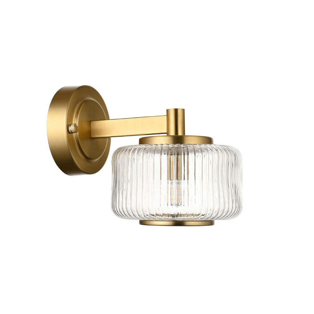 Vintage-inspired brass wall sconce featuring a fluted clear glass shade and elegant warm lighting detail.