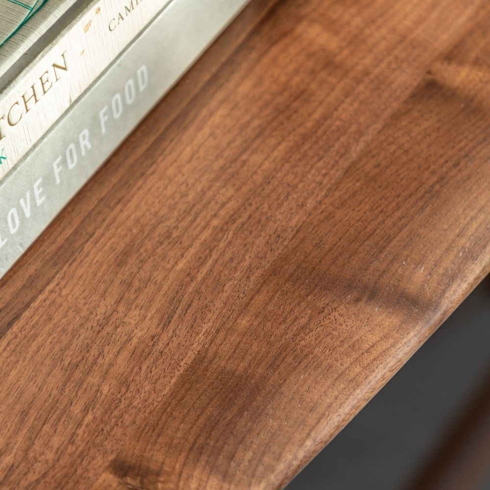Close up of solid walnut wood grain on a console table surface with natural texture and warm tones.