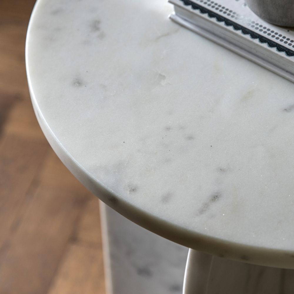 Close up of white marble tabletop highlighting fine grey veining and polished smooth finish.