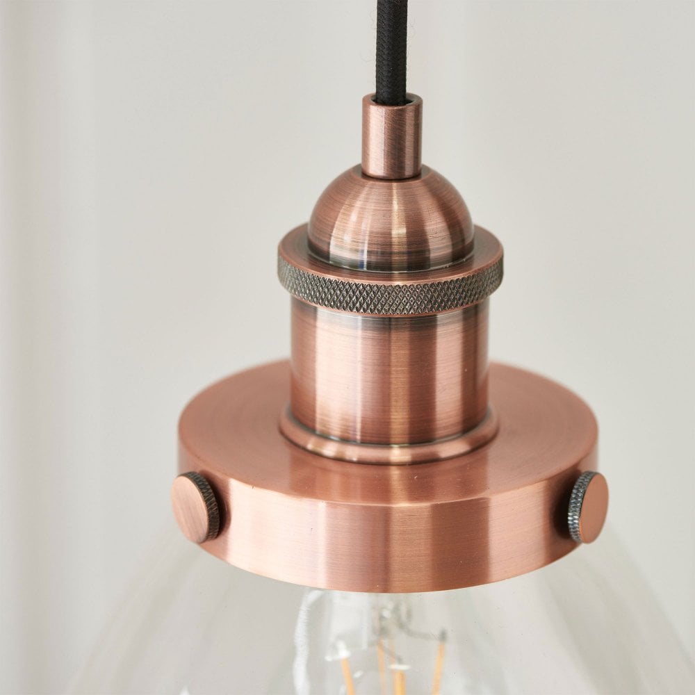Elegant industrial-style glass pendant light in a sleek copper finish, offering a striking focal point for any room.
