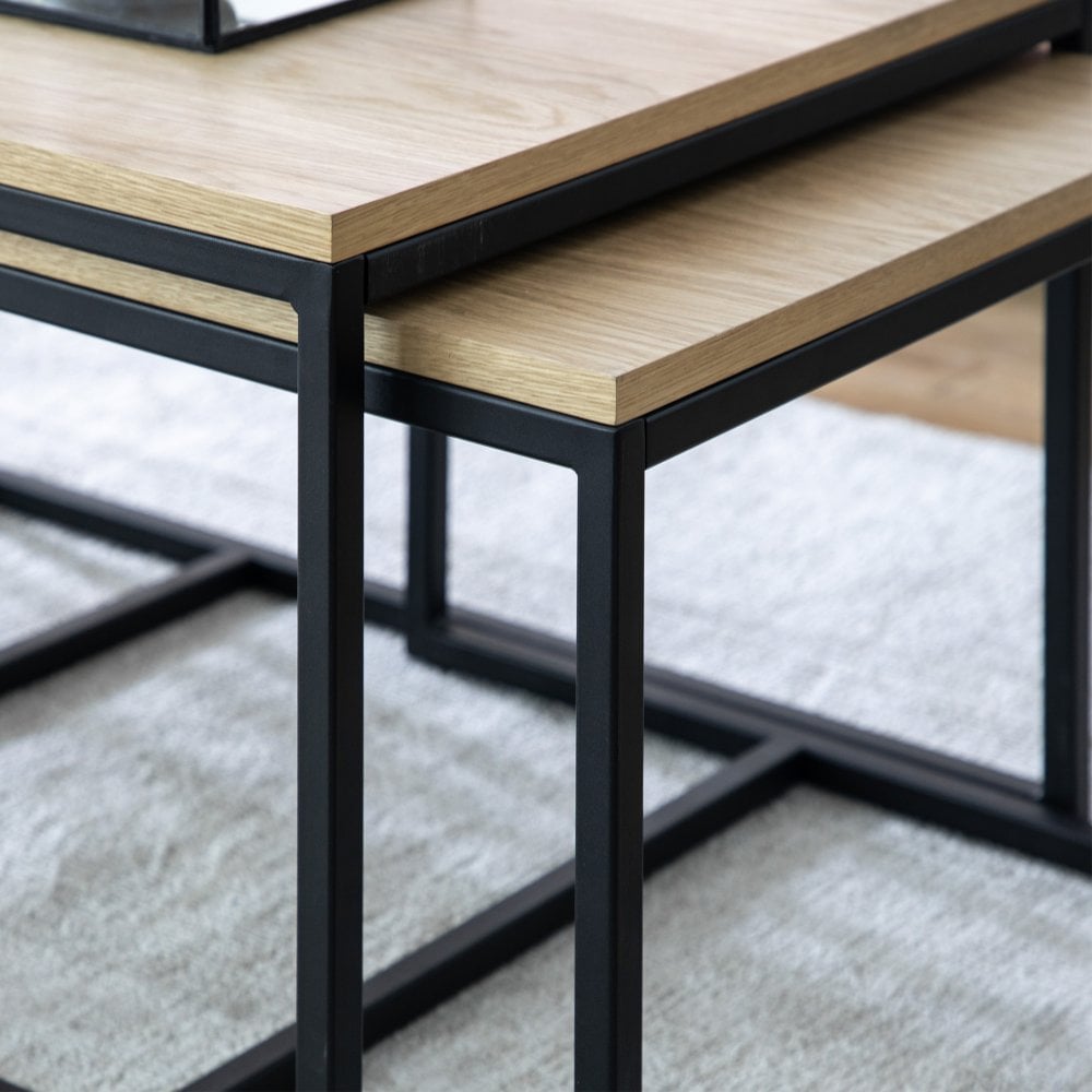 Enhance your home with this contemporary nest of three tables, designed with a durable oak veneer surface and a robust iron frame for an effortlessly chic industrial look.
